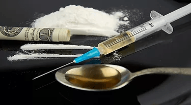 Drug concept: Needle, cocaine, dollar bill