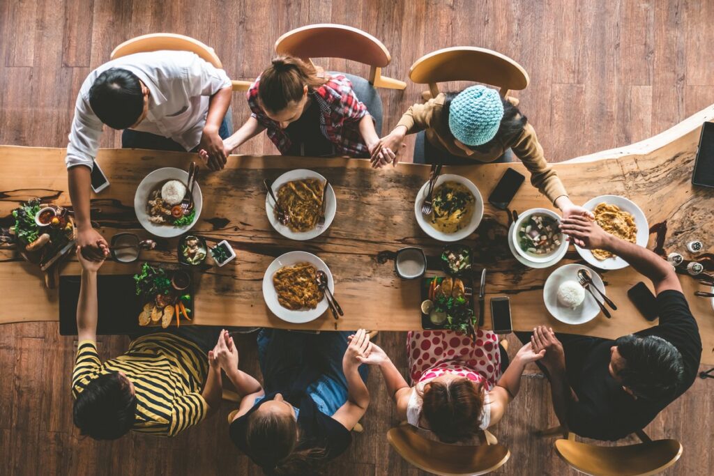 Group of friend pray before having food and drinks